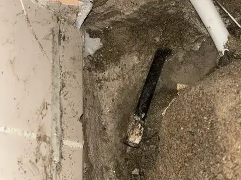 Opengehakte wand met blootgelegde afvoerleiding