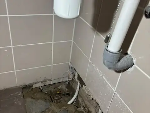 Sifon en afvoerleiding boven een opengemaakte vloer