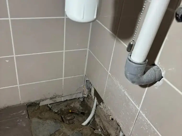 Sifon en afvoerleiding boven een opengemaakte vloer
